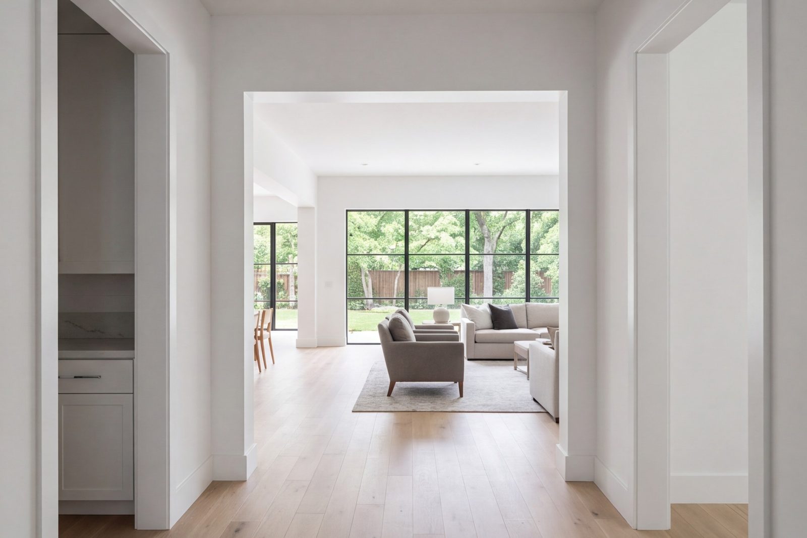 Hallway opening into a bright remodeled family room with new oak floors