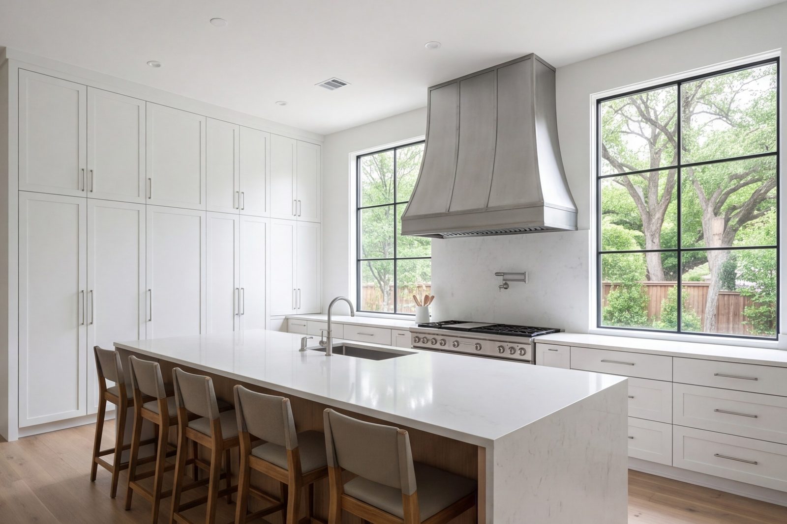 Wide modern kitchen with a long island, full-height cabinets and tall windows in a Dallas home